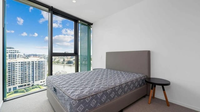 Bed with grey headboard and bedside table bedroom at Realm Kangaroo Point in Brisbane Student Accommodation