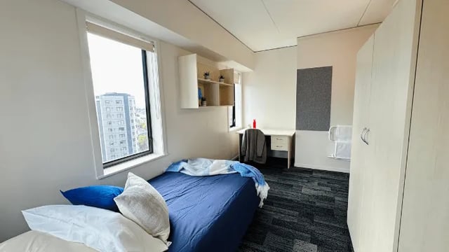 Bed desk wardrobe and shelves bedroom at Wellesley Apartments in Auckland Student Accommodation
