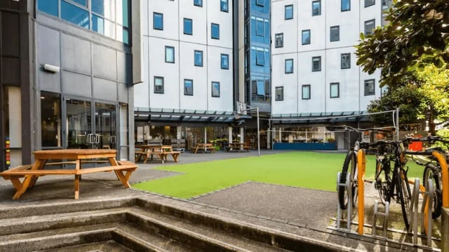Picnic tables bikes basketball court exterior at Wellesley Apartments in Auckland Student Accommodation