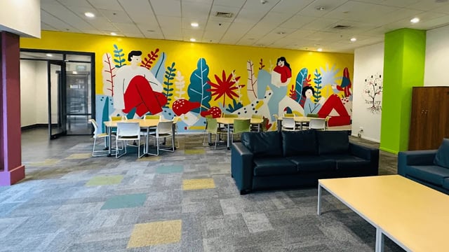 Colorful mural sofas tables chairs communal space at Wellesley Apartments in Auckland Student Accommodation