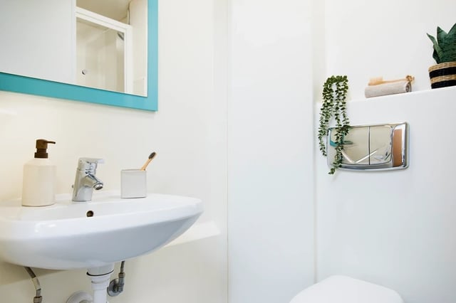 Sink soap dispenser toothbrush holder and toilet Bathroom at Ty Pont Haearn in Cardiff Student Accommodation