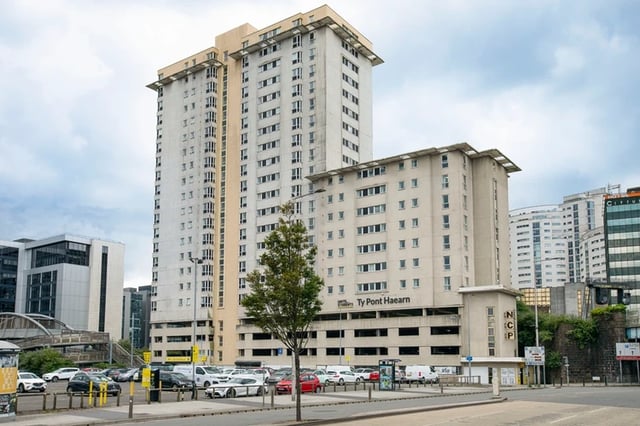 Tall student apartment buildings with parking lot exterior at Ty Pont Haearn in Cardiff Student Accommodation