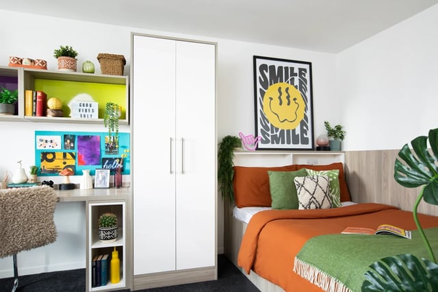 Wardrobe desk bed with colorful bedding bedroom at Ty Pont Haearn in Cardiff Student Accommodation