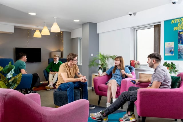 Students chatting in colourful lounge area living room at Ty Pont Haearn in Cardiff Student Accommodation
