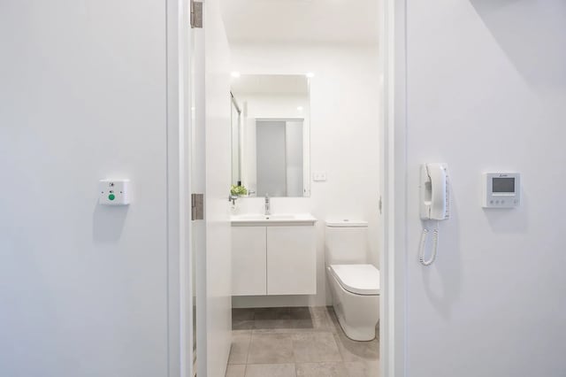 White sink toilet and wall mounted phone bathroom at dwell East End Adelaide in Adelaide Student Accommodation