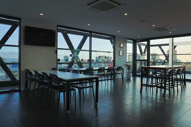 Tables chairs and cityscape view common area at dwell East End Adelaide in Adelaide Student Accommodation