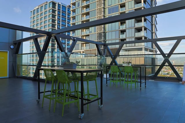 High tables green chairs outdoor seating area at dwell East End Adelaide in Adelaide Student Accommodation
