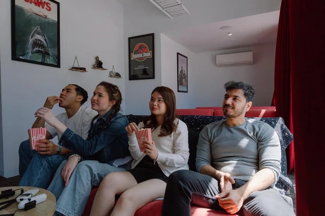 Students watching movie with popcorn living room at dwell Village Melbourne City in Melbourne Student Accommodation