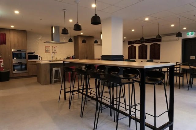 Kitchen counter with stools and kitchen area. at dwell Village Melbourne City in Melbourne Student Accommodation