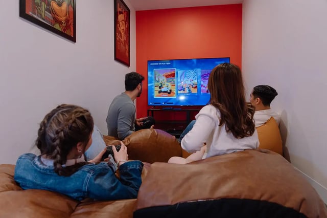 People playing video games on beanbags gaming room at dwell Village Melbourne City in Melbourne Student Accommodation