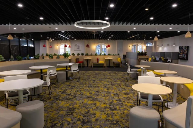 Modern lounge with tables chairs and sofas common area at dwell Village Melbourne City in Melbourne Student Accommodation
