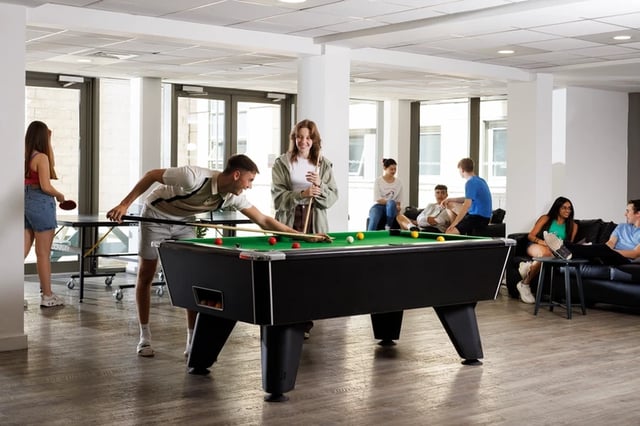 Students playing pool and relaxing in lounge at Sir Charles Groves Hall in Manchester Student Accommodation