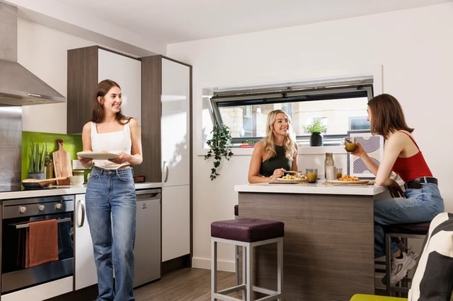 Students in modern kitchen with island living room at Sir Charles Groves Hall in Manchester Student Accommodation