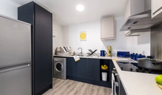 Modern kitchen with sink, washing machine, and appliances Kitchen at Pine Mill in Lincoln Student Accommodation