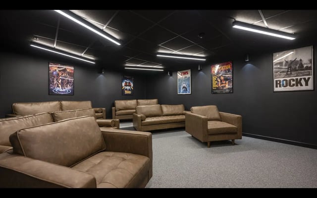 Brown leather sofas movie posters dark room cinema at Medici in Nottingham Student Accommodation