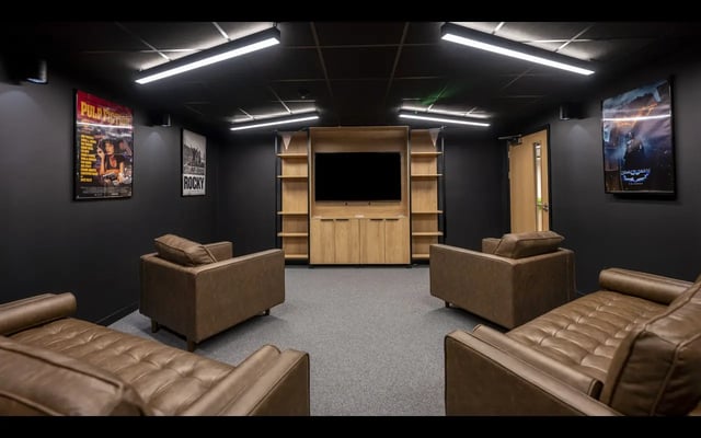 Leather sofas and chairs with entertainment unit living room at Medici in Nottingham Student Accommodation