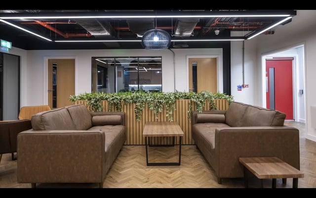 Brown couches plant wall and coffee table common area at Medici in Nottingham Student Accommodation