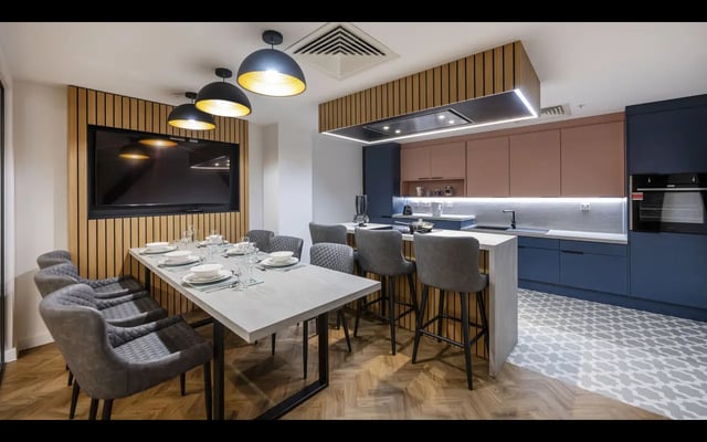 Dining table with chairs and modern kitchen area kitchen at Medici in Nottingham Student Accommodation