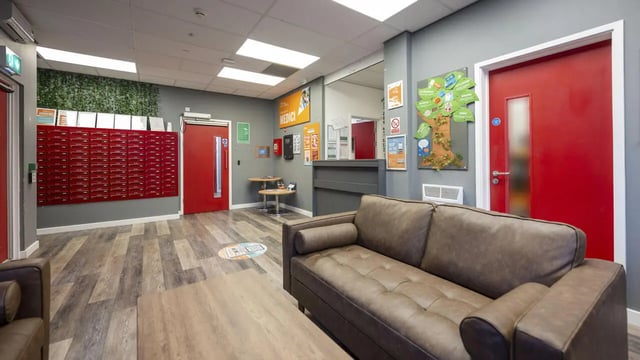 Sofa mailboxes red doors reception common area at Medici in Nottingham Student Accommodation