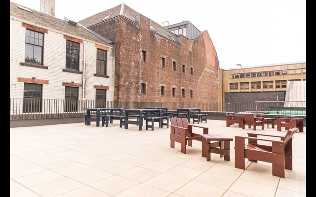 Red and blue seating on tiled patio exterior at Martha Street Apartments in Glasgow Student Accommodation