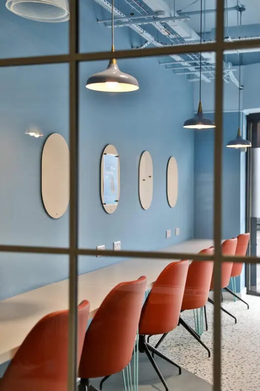 Orange chairs and oval mirrors study area at Ladybarn House in Manchester Student Accommodation