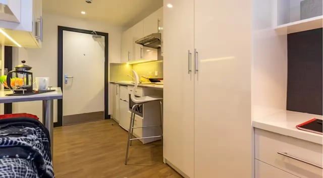 Kitchenette with high gloss cabinets and white bar stool kitchen at The Court Yard in Southampton Student Accommodation
