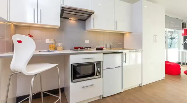 White bar stool microwave fridge cabinets kitchen at The Court Yard in Southampton Student Accommodation