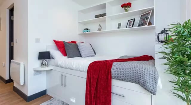Bed with red grey blankets bedside lamp shelves bedroom at The Court Yard in Southampton Student Accommodation