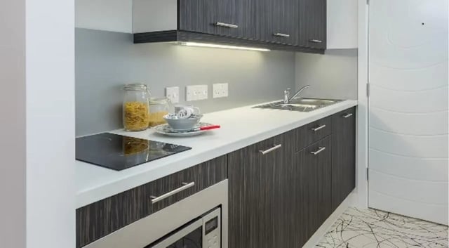 Modern kitchen with white countertop and dark cabinets kitchen at Queens Gate in Southampton Student Accommodation