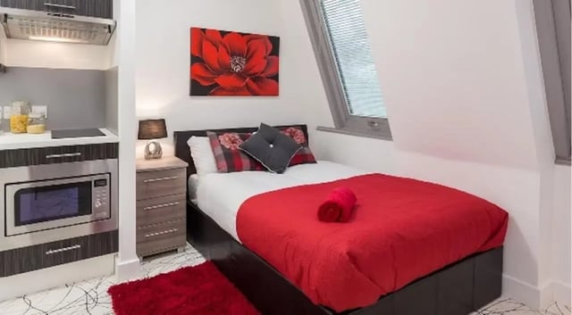 Bed microwave and kitchen area bedroom at Queens Gate in Southampton Student Accommodation