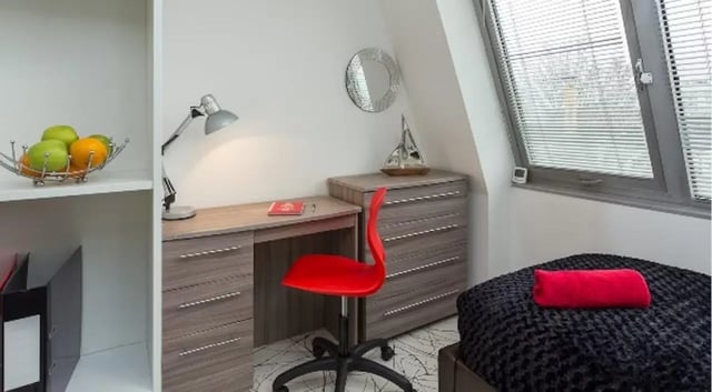 Desk chair lamp fruit bowl mirror and bed study area at Queens Gate in Southampton Student Accommodation