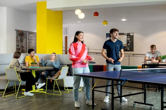 Students playing ping pong and relaxing in lounge at Orion Point in Southampton Student Accommodation