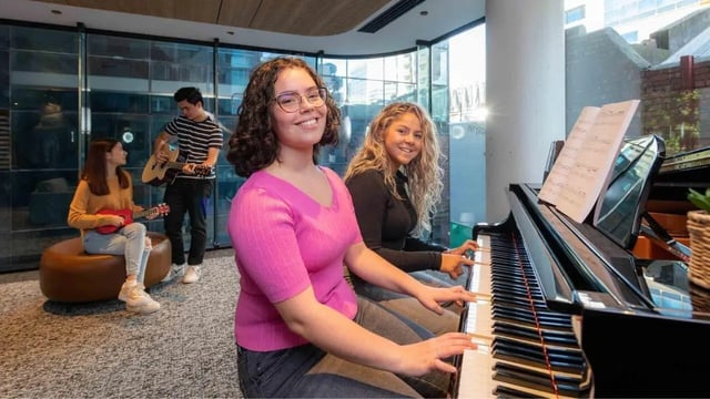 Students playing piano guitars ukulele common area at UniLodge Melbourne Central in Melbourne Student Accommodation