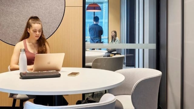 Student working at laptop communal seating area at Unilodge Melbourne City in Melbourne Student Accommodation
