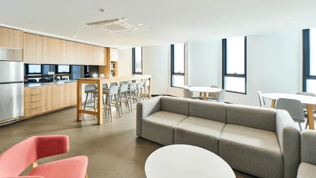 Kitchen with sofa tables and chairs living area at UniLodge Park Avenue in Melbourne Student Accommodation
