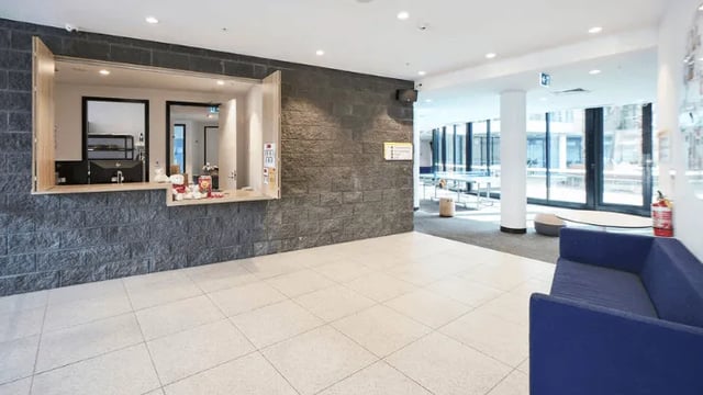 Reception desk with computer and seating area lobby at UniLodge Park Avenue in Melbourne Student Accommodation