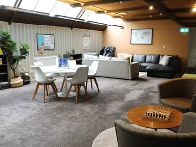 Dining table seating sofas chessboard lounge area at @the Lodge UNIVERSITY LIVING in Weatherford Student Accommodation