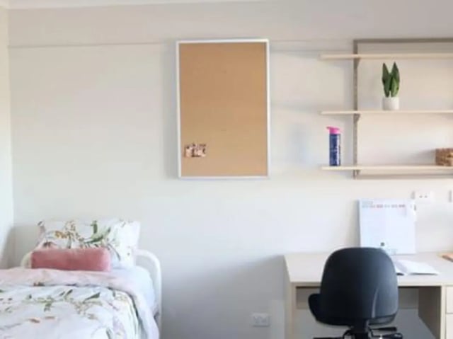 Bed desk corkboard shelves and chair bedroom at La Trobe University - Terraces in Melbourne Student Accommodation