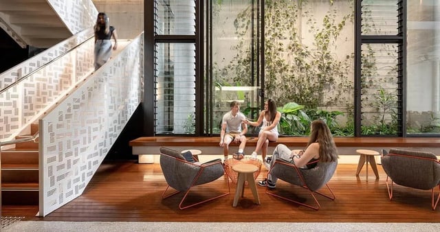 Chairs people and plants communal area at @the Lodge UNIVERSITY LIVING in Weatherford Student Accommodation
