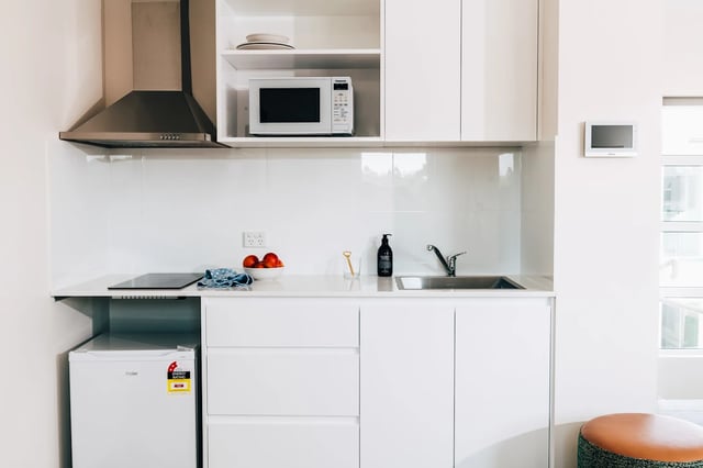Microwave sink fridge and induction cooktop kitchen at UKO Stanmore in Sydney Student Accommodation