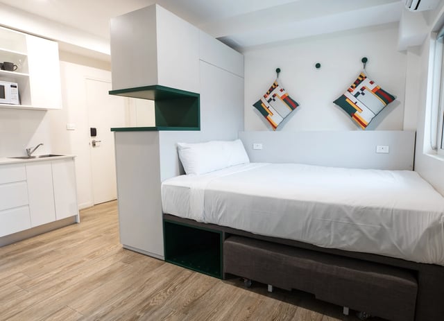 Bed desk and kitchenette in studio apartment. at UKO Stanmore in Sydney Student Accommodation