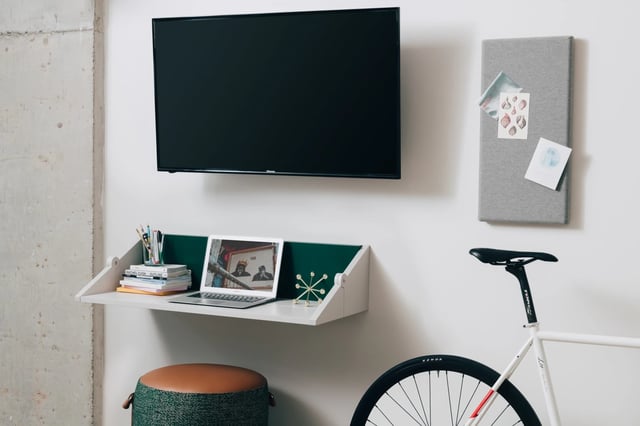 Desk with laptop television and bicycle study area at UKO Stanmore in Sydney Student Accommodation