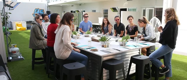 People gathered at a communal dining table outside living room at UKO Stanmore in Sydney Student Accommodation
