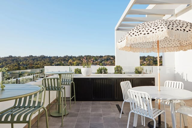 Outdoor kitchen with table chairs and umbrella exterior at UKO West Ryde in Sydney Student Accommodation