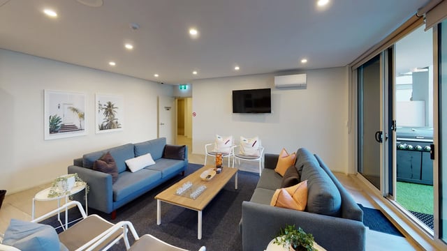 Sofas coffee table chairs artwork living room at UKO West Ryde in Sydney Student Accommodation