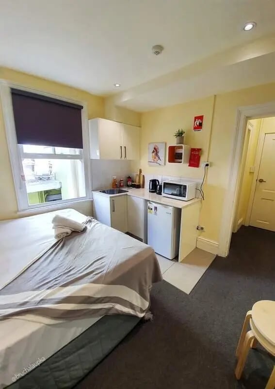 Bed kitchen sink microwave and fridge studio at ume 142 Darlinghurst Village in Sydney Student Accommodation