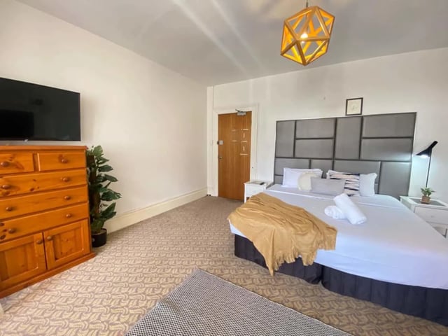 Bed dresser TV plant and headboard bedroom at ume 150 Darlinghurst Village in Sydney Student Accommodation