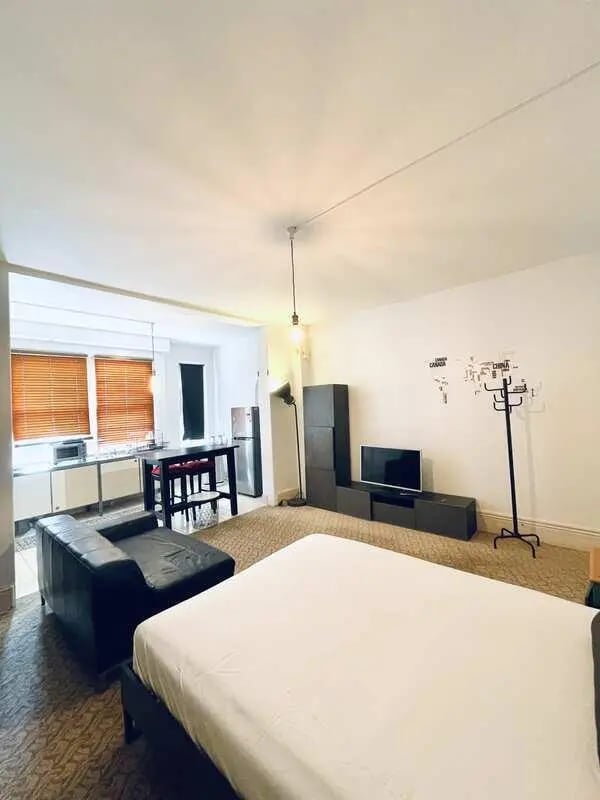 Bed couch kitchen dining table TV living area at ume 150 Darlinghurst Village in Sydney Student Accommodation