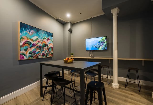 Table with stools artwork and television communal area at ume Haymarket in Sydney Student Accommodation