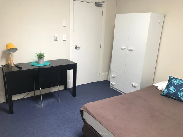 Desk lamp plant wardrobe and bed bedroom at ume Redfern in Sydney Student Accommodation